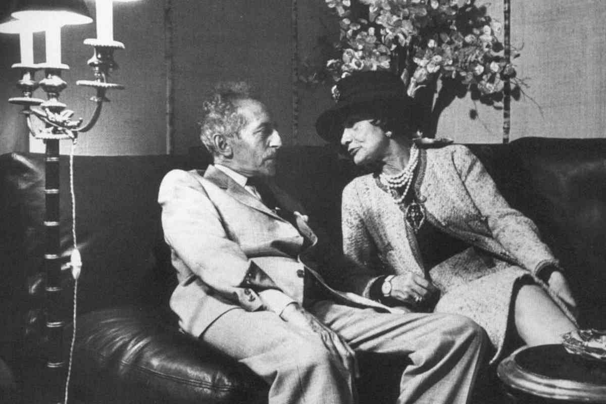 Coco Chanel, a la derecha, charla con un ministro francés de la época en un sofá.