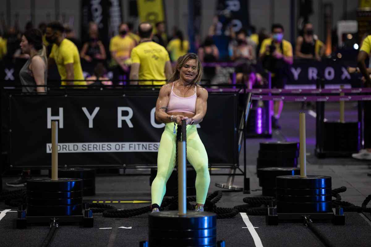 Una mujer compitiendo en crossfit donde se combina fuerza y velocidad.